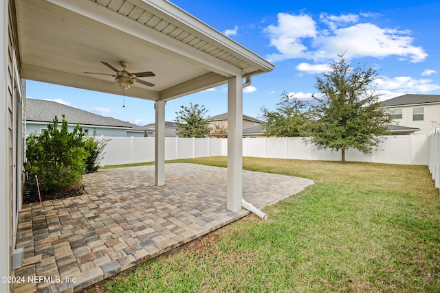 view of yard with ceiling fan and a patio