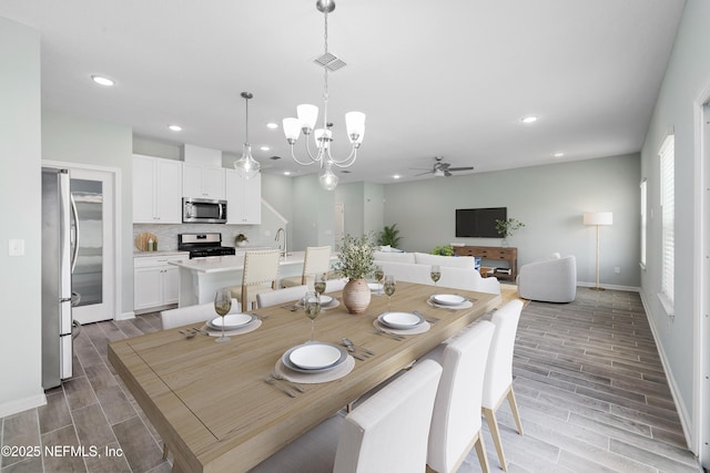 dining space featuring ceiling fan with notable chandelier