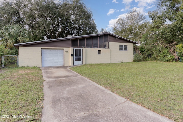 single story home featuring a sunroom, a front yard, and a garage