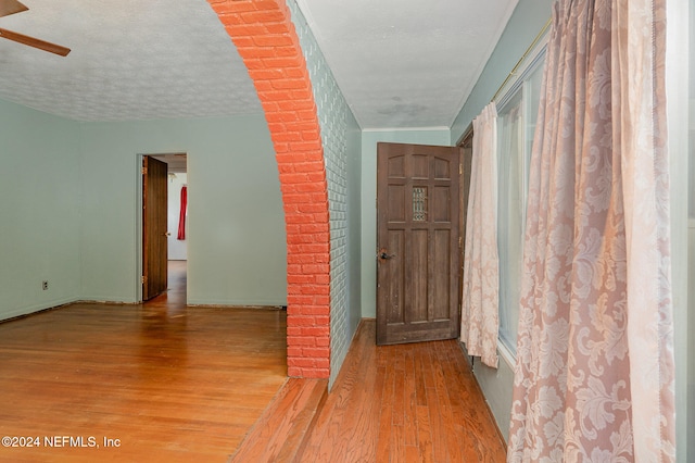 hallway featuring a textured ceiling and light wood-type flooring