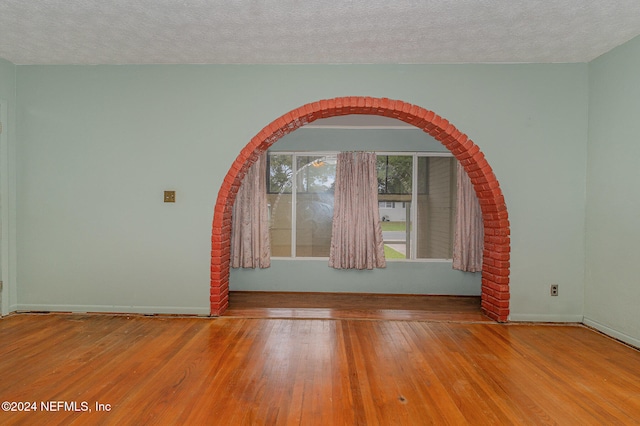 empty room featuring light hardwood / wood-style flooring and a textured ceiling