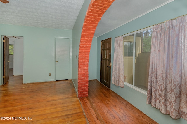 spare room featuring a textured ceiling and light hardwood / wood-style floors