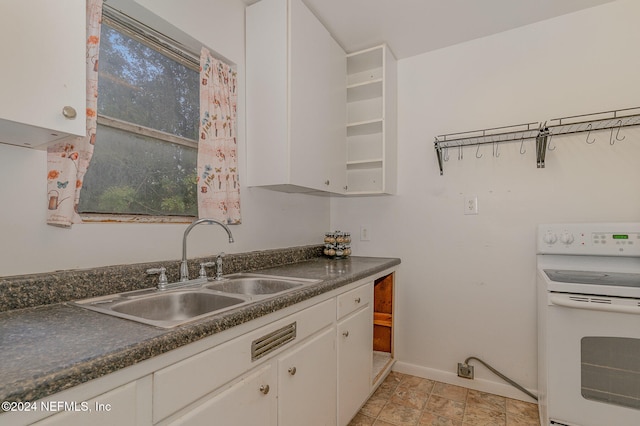 kitchen with sink, white cabinets, and white electric stove