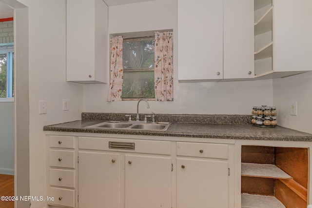 kitchen with white cabinets, sink, and hardwood / wood-style floors