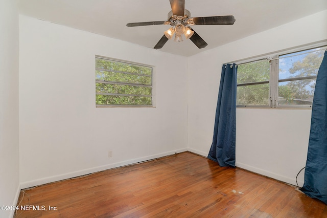 unfurnished room with ceiling fan and hardwood / wood-style flooring