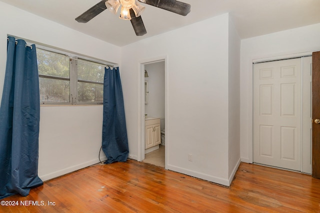 unfurnished bedroom featuring ceiling fan, light hardwood / wood-style floors, a closet, and ensuite bathroom