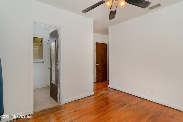 unfurnished bedroom featuring ceiling fan, connected bathroom, and light hardwood / wood-style flooring