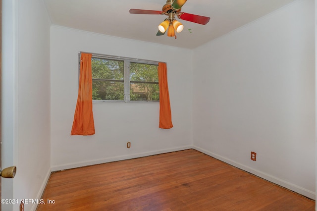 empty room featuring wood-type flooring, ceiling fan, and crown molding