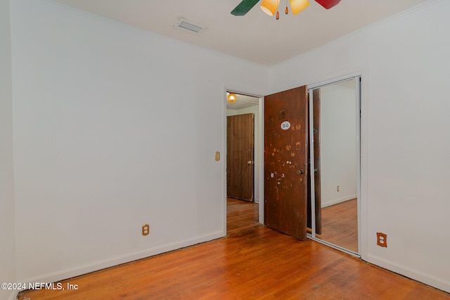 empty room featuring hardwood / wood-style flooring, ceiling fan, and ornamental molding