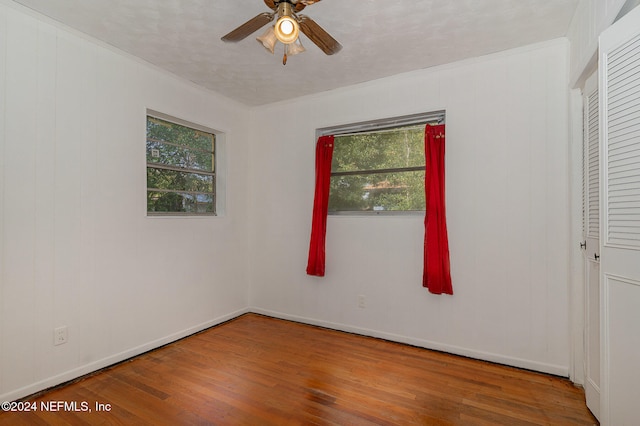 empty room with ceiling fan, crown molding, and hardwood / wood-style flooring