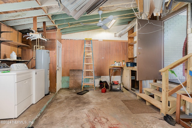 basement featuring washer and dryer, wood walls, and water heater