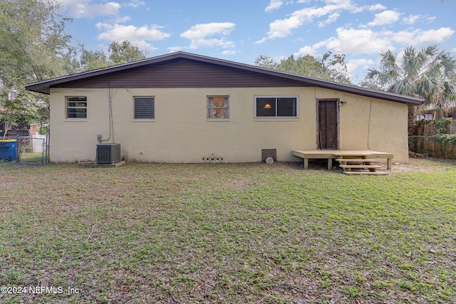 back of property featuring a yard and central AC unit