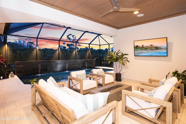 view of patio / terrace featuring ceiling fan, a lanai, and an outdoor living space with a fire pit