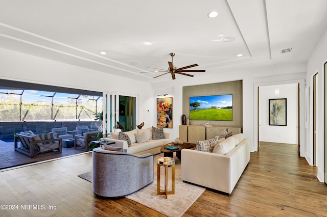 living room featuring light hardwood / wood-style flooring and ceiling fan