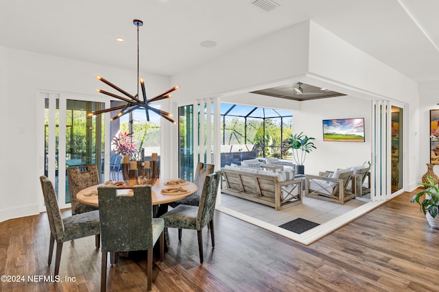 dining space with a notable chandelier, wood-type flooring, and a wealth of natural light