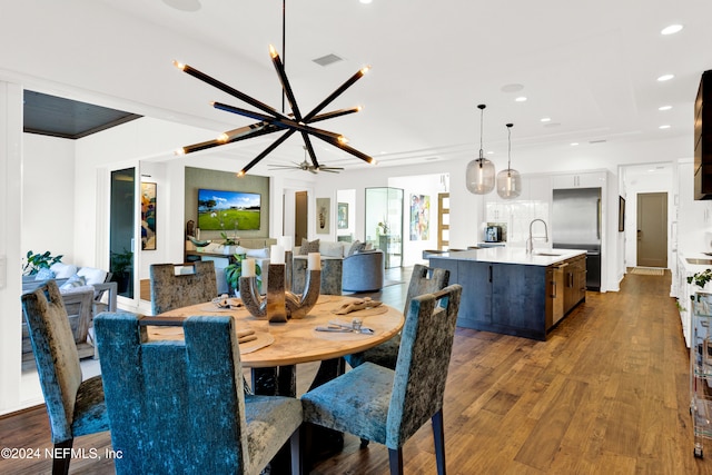 dining space with ceiling fan with notable chandelier and dark hardwood / wood-style floors