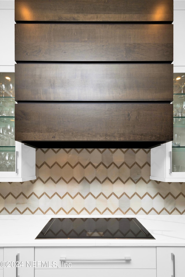 kitchen with white cabinets, decorative backsplash, black electric stovetop, and exhaust hood