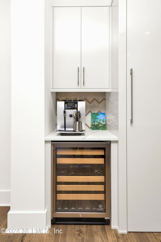 bar featuring white cabinets, hardwood / wood-style floors, decorative backsplash, and beverage cooler