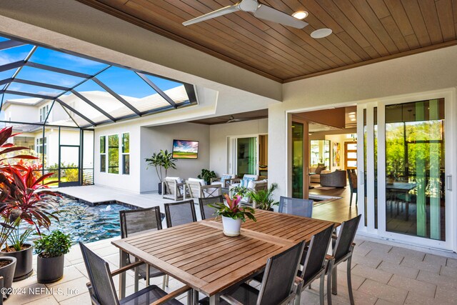 view of patio with ceiling fan and a lanai