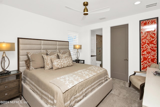 carpeted bedroom with ensuite bathroom and ceiling fan