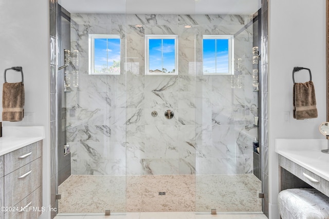 bathroom featuring vanity, a shower with door, and a wealth of natural light