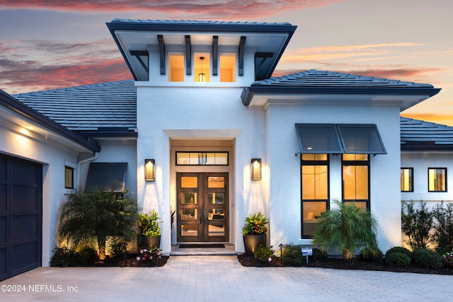 exterior entry at dusk featuring french doors