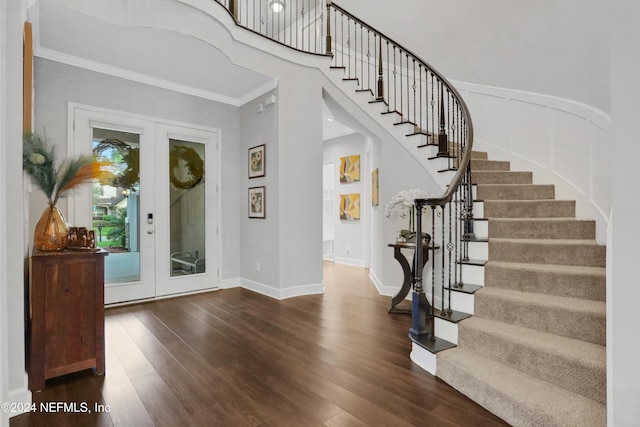 entrance foyer with ornamental molding, french doors, and dark hardwood / wood-style floors