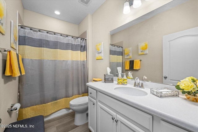 bathroom featuring vanity, wood-type flooring, toilet, and walk in shower