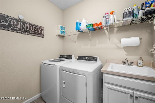 laundry room featuring washer and dryer, sink, and cabinets