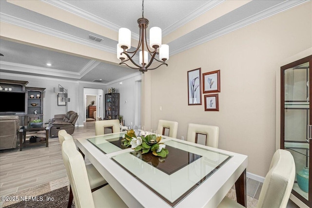 dining space featuring crown molding, light hardwood / wood-style floors, and a notable chandelier