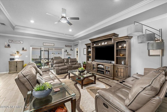 living room featuring a raised ceiling, crown molding, and a textured ceiling