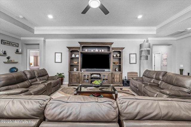 living room with crown molding, a tray ceiling, and a textured ceiling