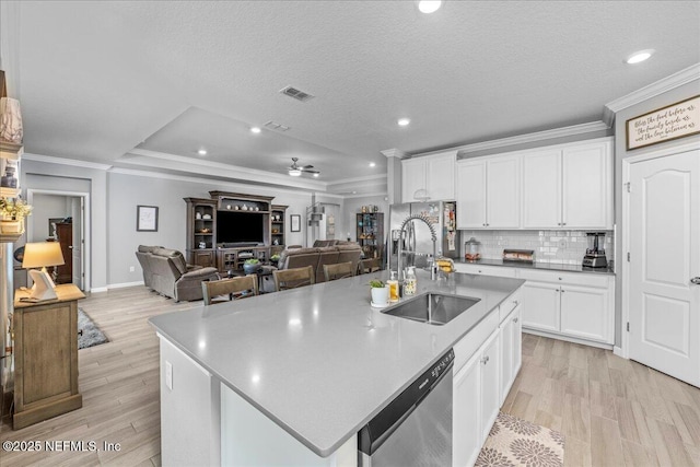 kitchen with sink, white cabinetry, a textured ceiling, stainless steel dishwasher, and an island with sink