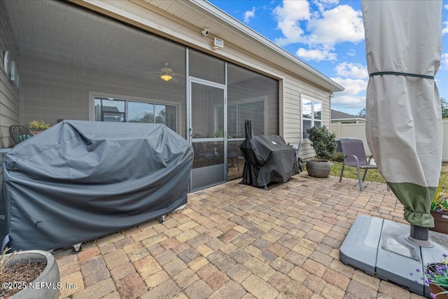 view of patio with area for grilling and a sunroom