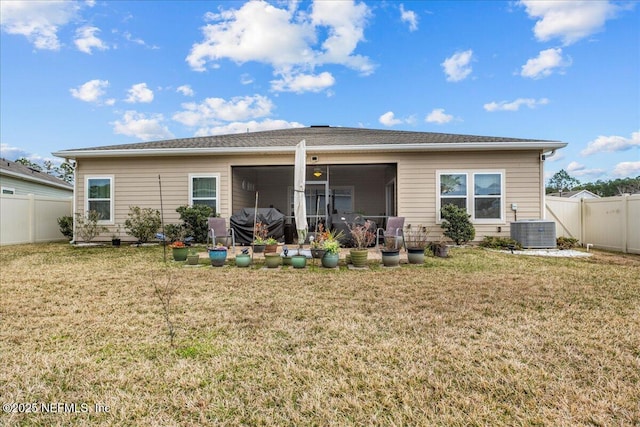 back of house with a lawn, a sunroom, and central air condition unit