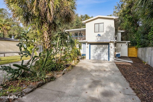 view of front of house with driveway, a garage, and fence