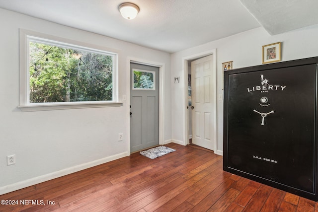 foyer featuring baseboards and dark wood-style flooring