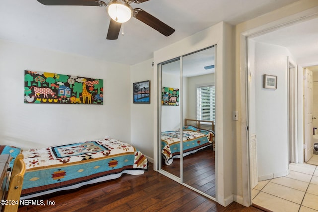 bedroom with a closet, baseboards, ceiling fan, and hardwood / wood-style flooring