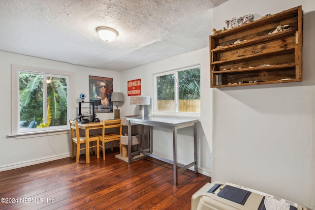 office space with a textured ceiling, dark wood-type flooring, and baseboards