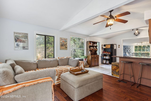 living area featuring hardwood / wood-style flooring, vaulted ceiling with beams, and a ceiling fan