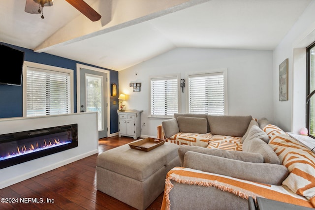 living room featuring dark wood-type flooring, lofted ceiling, a ceiling fan, a glass covered fireplace, and baseboards