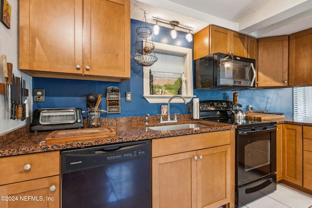 kitchen with sink, dark stone countertops, a textured ceiling, light tile patterned floors, and black appliances