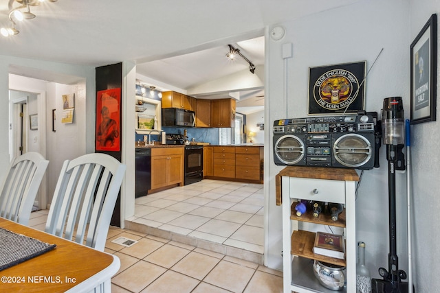 kitchen featuring light tile patterned floors, a sink, black appliances, track lighting, and brown cabinets