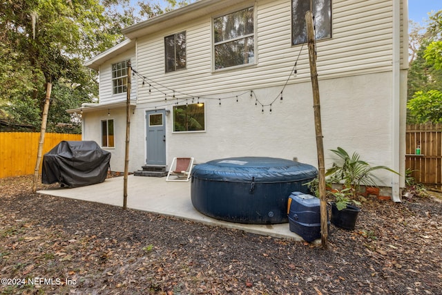 rear view of house featuring a pool, stucco siding, a patio, and fence