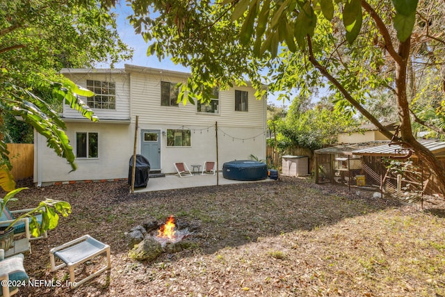 back of house featuring a patio, fence, an outbuilding, and an outdoor fire pit