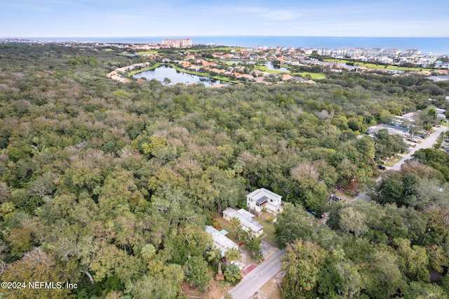 drone / aerial view with a forest view and a water view