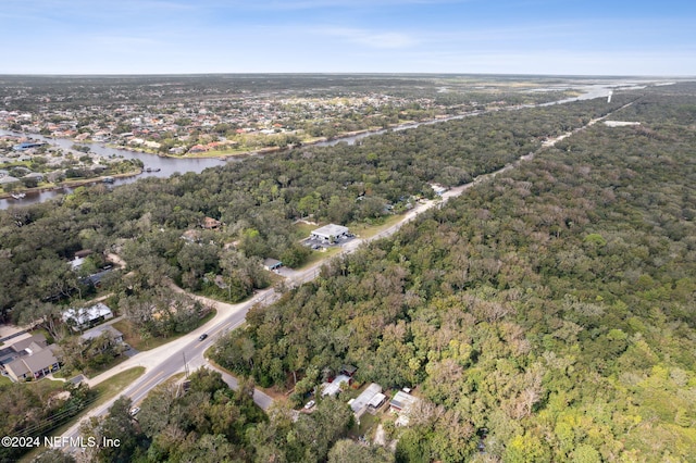 birds eye view of property featuring a wooded view and a water view