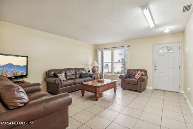 tiled living room featuring a textured ceiling