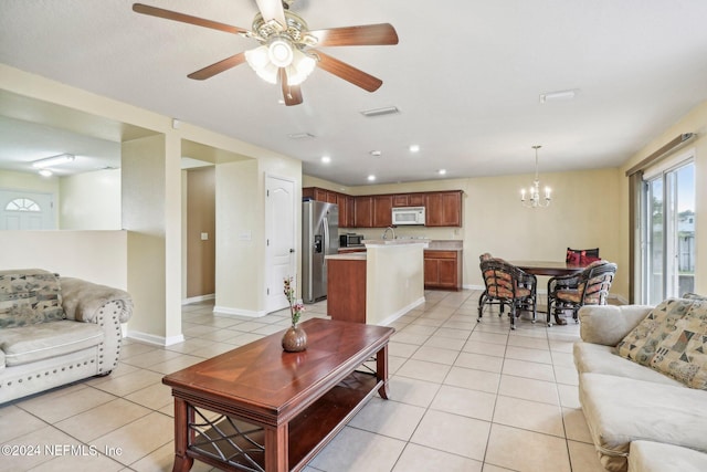 tiled living room featuring ceiling fan with notable chandelier