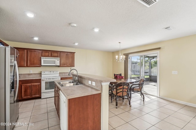 kitchen featuring sink, an island with sink, decorative light fixtures, white appliances, and light tile patterned floors